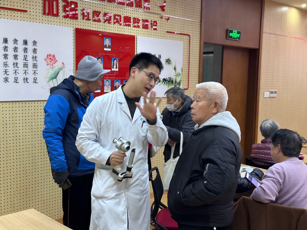 薛佳宇為老人做檢查并回答咨詢問(wèn)題(1).jpg